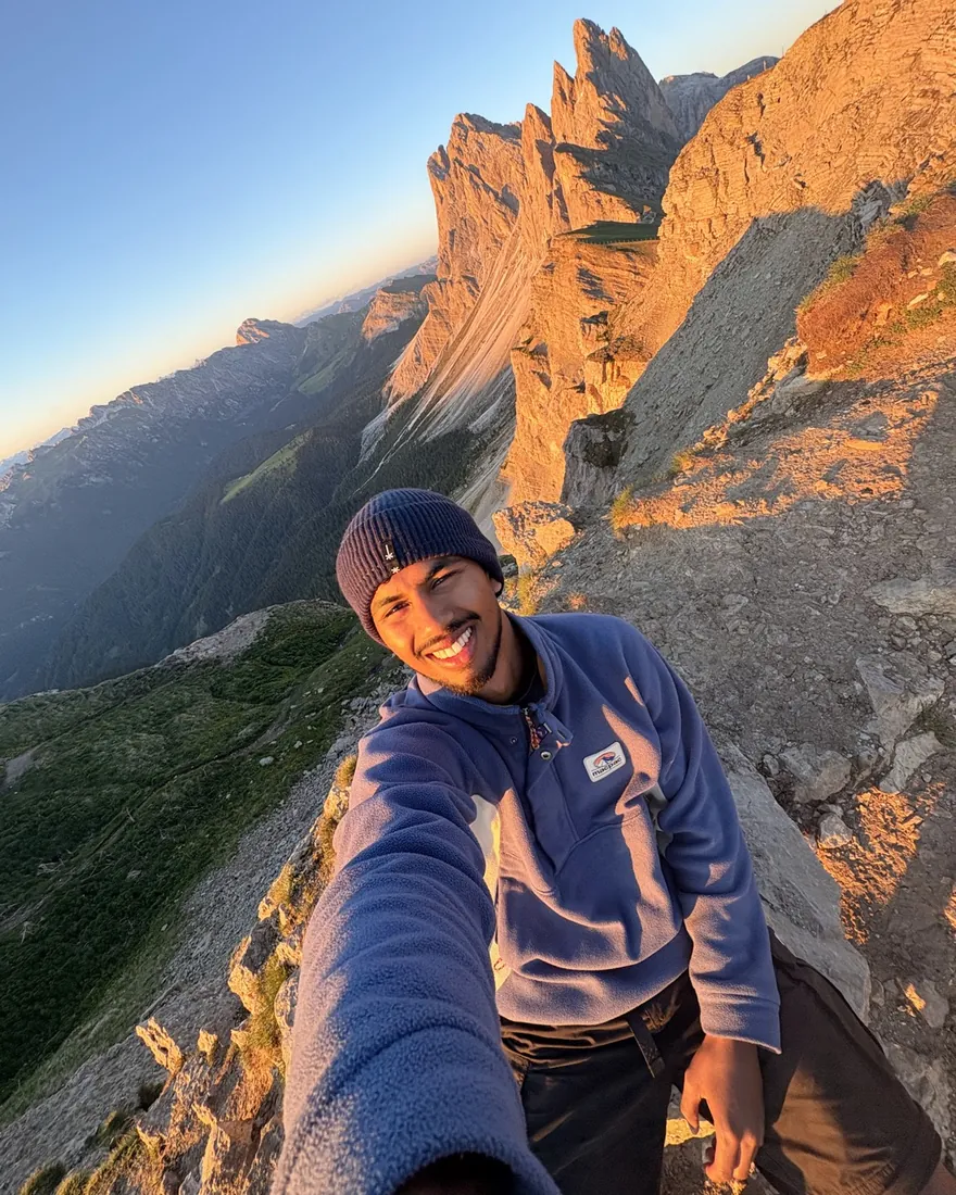 Punji smiling on a mountain ridge at sunrise